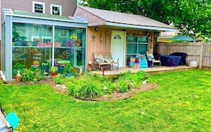 Backyard garden oasis. Fish pond with 2 more patios & glass greenhouse backdrop.