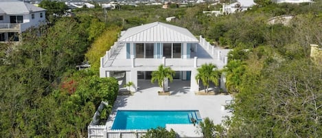 Aerial view of the front side of the house showing spacious patios and pool deck