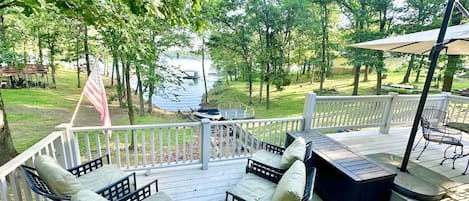 Upper deck with lake view, outdoor seating, and covered outdoor dining 