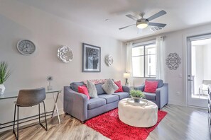 Relax in a cozy, light-filled living room with plush seating and a smart TV for your entertainment.