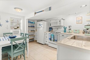 Fully equipped kitchen with dining area, pots, pans, plates, utensils and all kitchen appliances