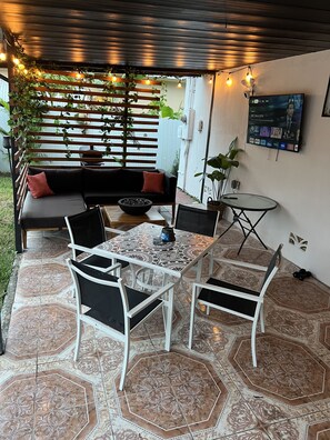 Covered Patio has Smart TV and common living and dining area. 