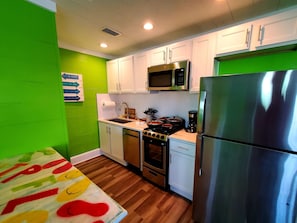 Fully equipped kitchen with dishwasher, gas stove, coffee maker & more
