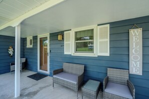 Covered front porch with seating and a warm welcome to greet every guest.
