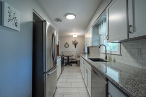 Modern kitchen with granite counters, stainless appliances, and dining nook.