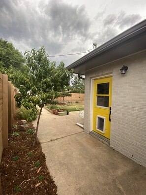 View of the entrance to the unit with the backyard visible in the background.