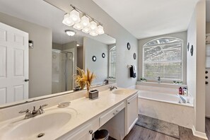 Master Queen bathroom completer with a large vanity. tub, and a walk-in shower