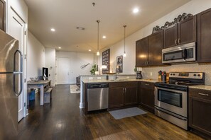 Open concept kitchen with stainless steel appliances and bar seating.