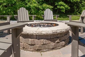 Stone gas firepit perfect for evening s'mores and stories.








