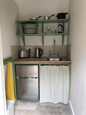 Compact kitchen area: fridge/freezer, induction hob, microwave, toaster, kettle