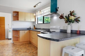 The kitchen has an oven and cooktop, microwave and fridge/freezer.