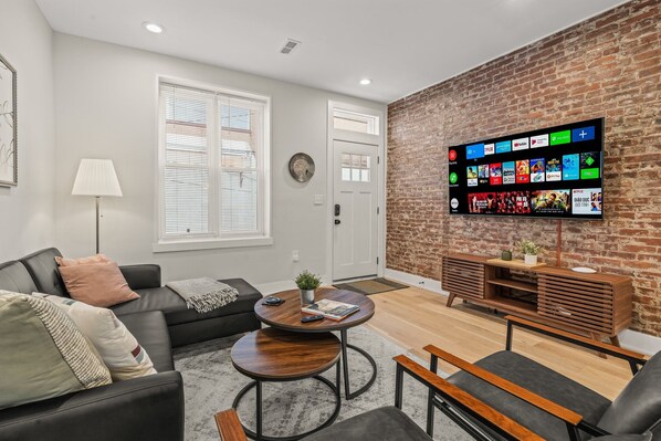 Enjoy the welcoming ambiance of this bright living area with natural light streaming through the windows. The modern furniture and beautiful rug make it the perfect place to unwind after a day of exploring.