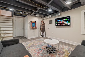 View of our Pac Man arcade game in the finished basement - kids and adults love it!  Life size Ben Franklin cut out (not actually Ben Franklin lol), and our 42 inch Roku smart TV.