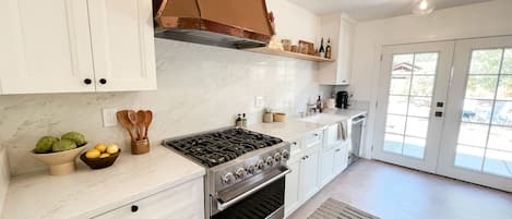 Enjoy the bright and airy kitchen with quartz countertops. Fully stocked. 