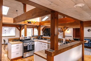 main level kitchen is center of the room. there are a bar table that goes around so people that cook can interact with other guests. perhaps a cooking show?