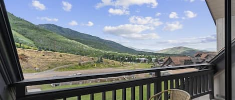 The stellar view of the mountains, resort base and chair lifts as seen from the private balcony, with its patio table and seats for two.