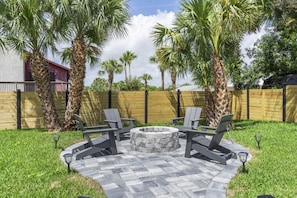 The backyard is pure magic—follow the paved path to a cozy firepit, relax in quality Adirondack chairs, fire up the propane grill, and dine al fresco at the outdoor table.