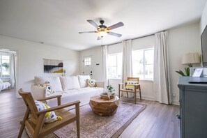 Quaint and cozy living room with a soft couch and Smart TV—perfect for relaxing after a day at the beach.