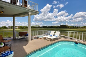 Sunny outdoor oasis with a private pool and hot tub.