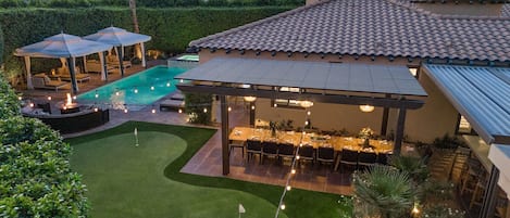 The property features a putting green, outdoor dining for up to 20 under a pergola, large outdoor kitchen, bocce and more!