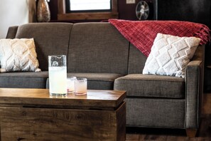 Relax after a day of riverfront fun in this open-concept living room featuring a full sofa, fireplace, and smart TV. The second-floor setting offers privacy, natural light, and balcony views from inside. Fast WiFi and comfort included.