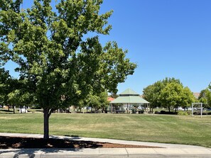 The house is looking at the large park. It has kids play area and walkways.