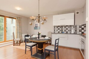 The combined living and dining area has a sofa, small dining table, and a partial view of the kitchen.