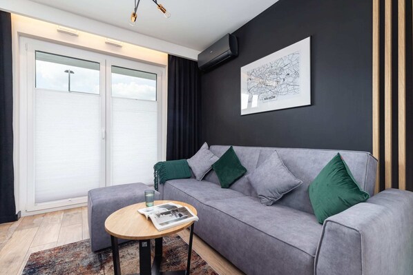 The living area features a sleek coffee table and a flat-screen television.
