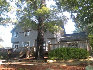 Lakeside view of house with enclosed deck the full length of house.  Hot tub