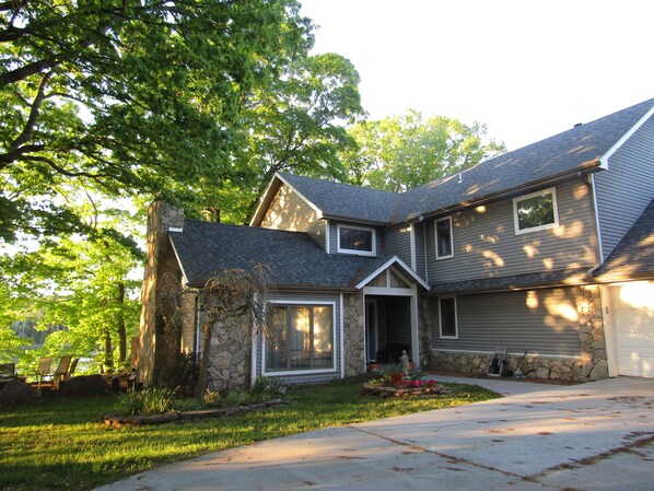 Front of house. Covered front porch.  Oak grove and majestic maple trees