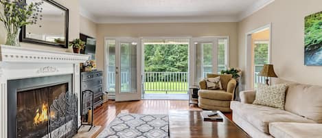 Living room leads out to wrap around porch and view of the yard