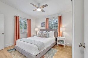 Colorful and cozy coastal main bedroom with bathroom attached.