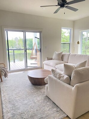 Plush couch with beautiful lake views and a large smart tv