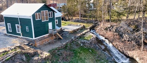 Back of the cottage showing the creek running alongside it.