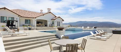 Stunning pool surrounded by open space and views.