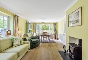 Hope Cottage, Shipton Gorge: The open-plan sitting and dining room with wood burning stove