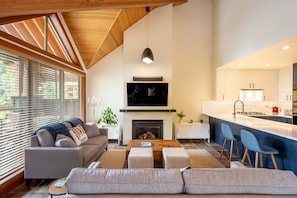 Stunning high ceiling in the living room with the fireplace looking out onto a private balcony