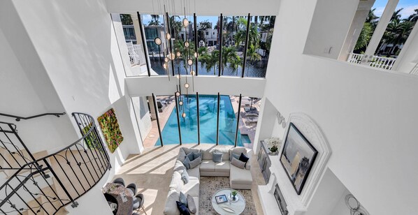 This Mediterranean coastal open floor plan villa offers waterfront views from the double ceiling living room.