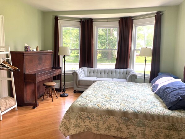 Bedroom/Living Room: king size bed, couch, piano, garment rack