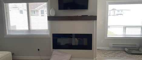 Cozy fireplace along with baseboard heater in the bathroom 