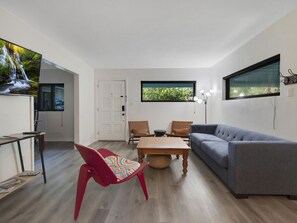 Mixed furnishings give eclectic look. View from kitchen.