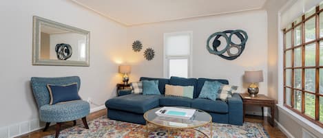 Main floor living space, with lots of cozy seating and natural light coming in. 