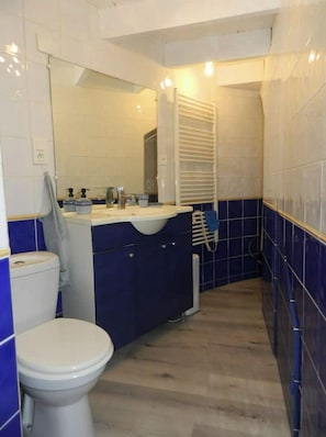 la salle de bain. La baignoire est au fond
