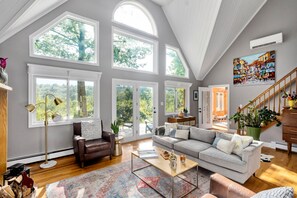 Two-story living room with a fireplace and panoramic views of the mountains 