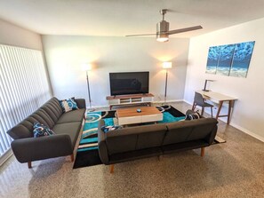 Unique modern contemporary beach design in Deerfield Beach. The Living Room has a dedicated workspace, large screen TV, and fold-out sofa beds. This beautifully decorated room has modern furniture and an upscale feel.