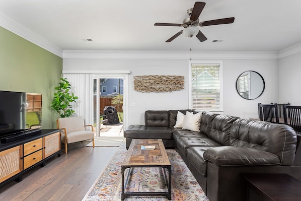 Living room with sectional and two sitting chairs & premium cable from Xfinity