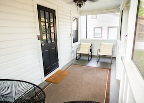 Screened in porch with rocking chairs.