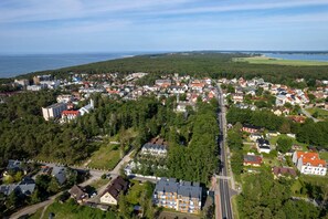 A panoramic view of the property’s location, showcasing greenery, nearby buildings, and the ocean in the background.