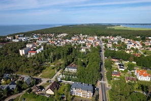 A panoramic view of the property’s location, showcasing greenery, nearby buildings, and the ocean in the background.