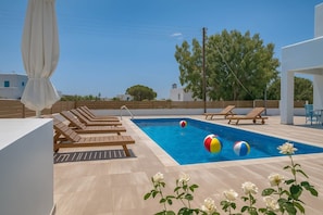 Shared Pool with Sea View Loungers
Relaxing pool scene with loungers and partial sea view in the distance, ideal for sunbathing.